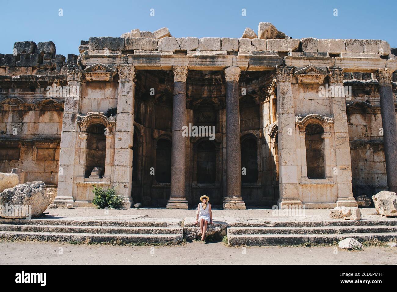 Una donna si siede nei templi di Baablbek Foto Stock