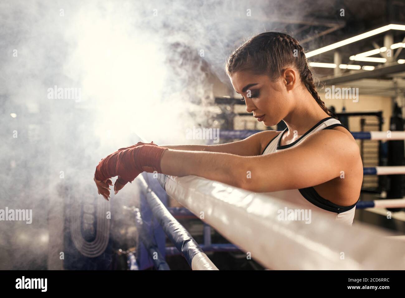 stanco caucasico donna pugile in piedi appoggiati sulla recinzione, dopo un riuscito addestramento nel ring. Concetto di sport Foto Stock