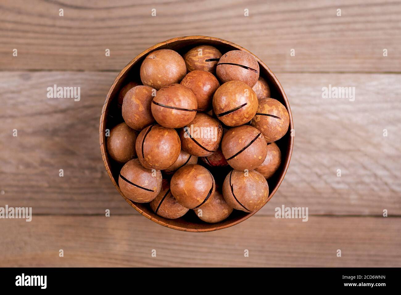 Noci di macadamia naturale organica in ciotola su tavola di legno piatto Vista dall'alto i noci di snack sani contengono l'olio essenziale ricco di vitamine B e PP, molto Foto Stock