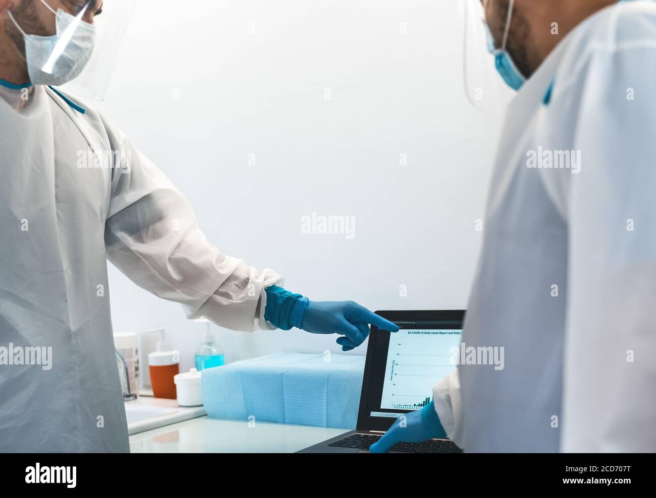 Medici specialisti che lottano contro l'epidemia di corona virus - Scienza e lavoro di squadra medico che esamina la grafica dei casi pandemici Foto Stock