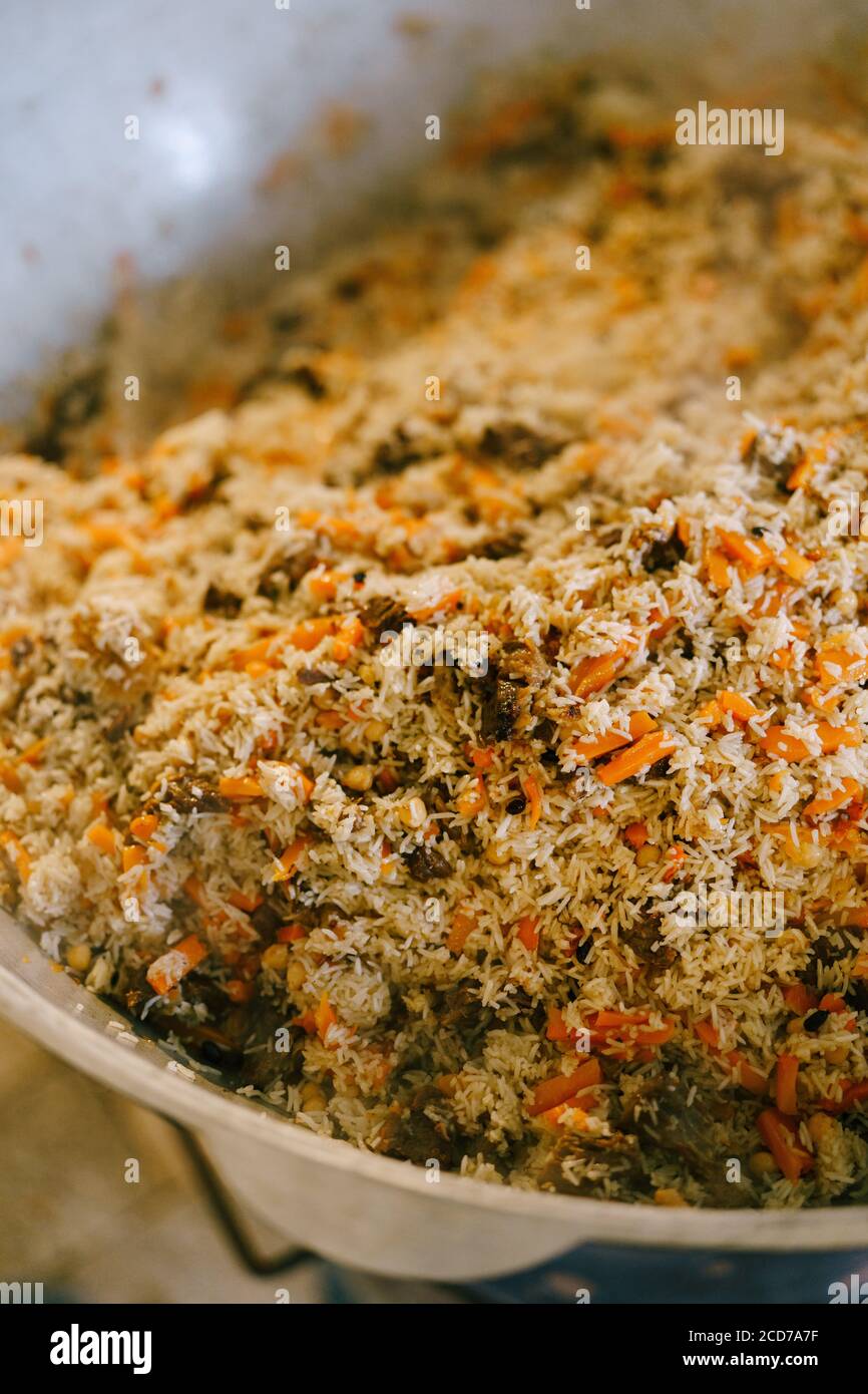 Primo piano del pilaf uzbeko finito in azan. La consistenza del riso, della carne e delle carote. Foto Stock