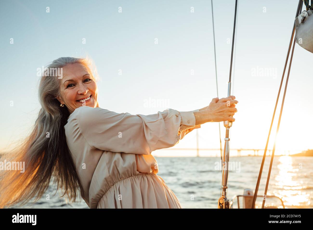 Bella donna anziana in piedi su uno yacht e guardando fotocamera Foto Stock