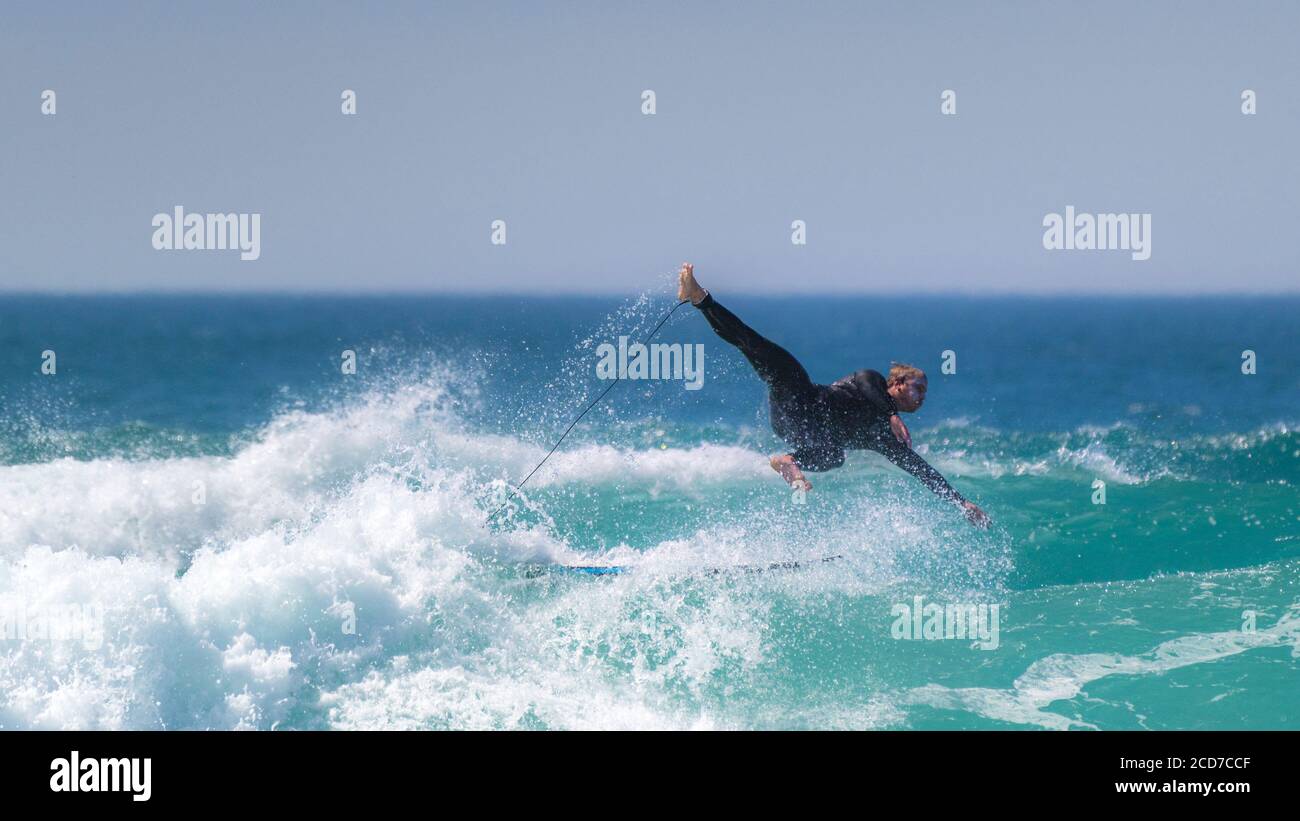 Una vista panoramica dell'azione spettacolare selvaggia mentre un surfista si asciuga a a Fistral a Newquay in Cornovaglia. Foto Stock