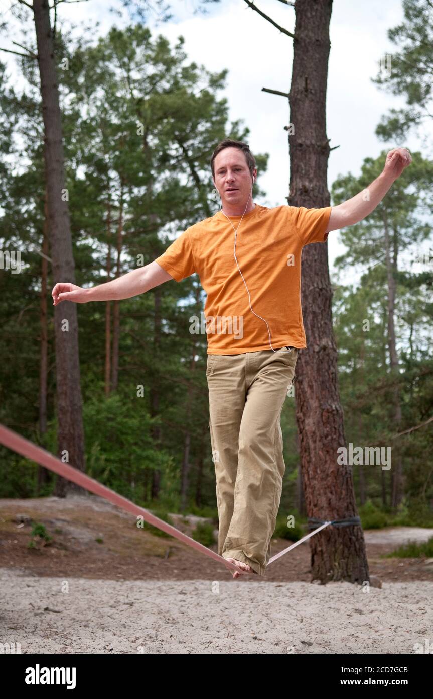 L'uomo che bilancia su Slackline nelle foreste di Fontainebleau Foto Stock