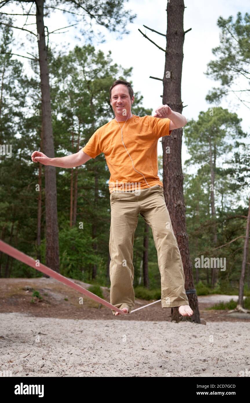 L'uomo che bilancia su Slackline nelle foreste di Fontainebleau Foto Stock