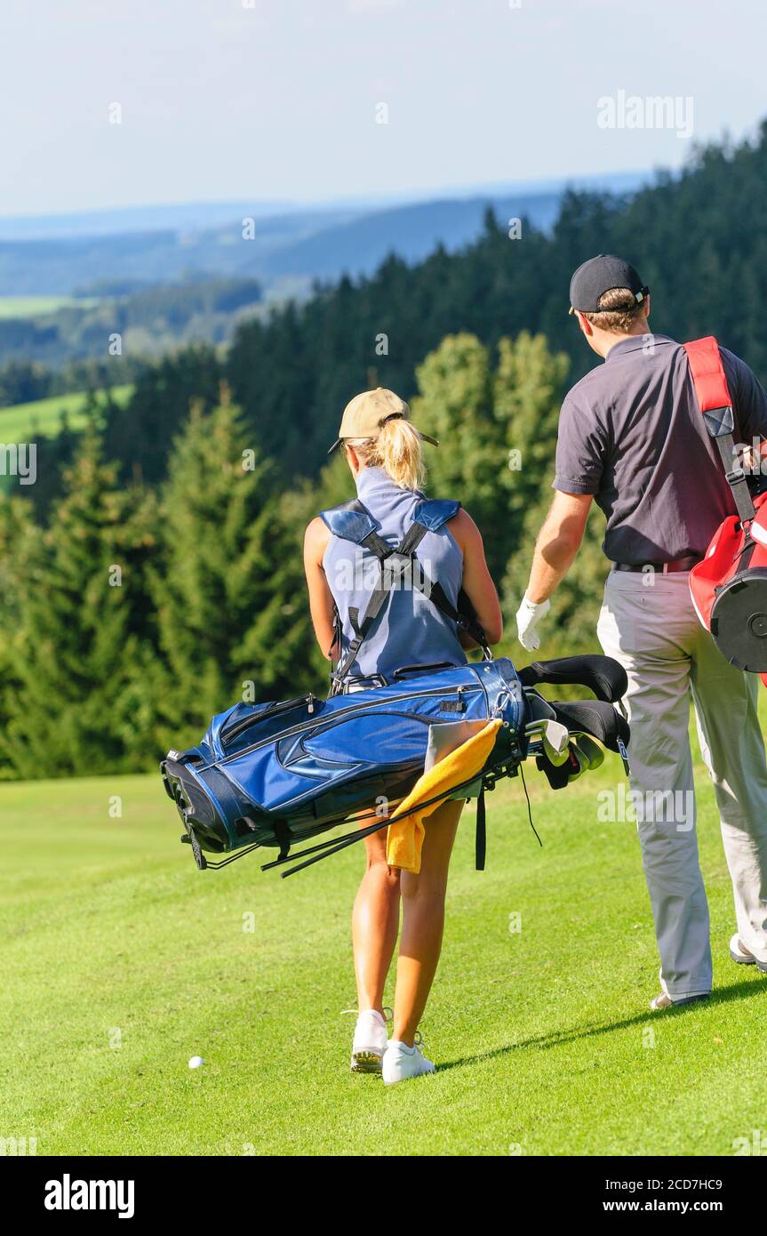 L uomo e la donna a giocare a golf su un bellissimo parco corso in una giornata di sole in estate Foto Stock