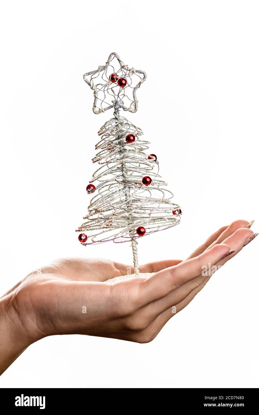 Mano che tiene piccolo filo argento albero di Natale isolato su bianco sfondo Foto Stock