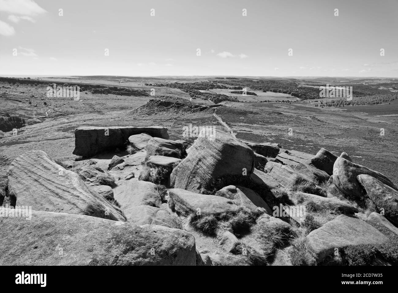 Dalle rocce di pietra grintosa di Higger Tor sopra il forte Carl Wark e Hathersage Moor. Immagine in bianco e nero. Foto Stock