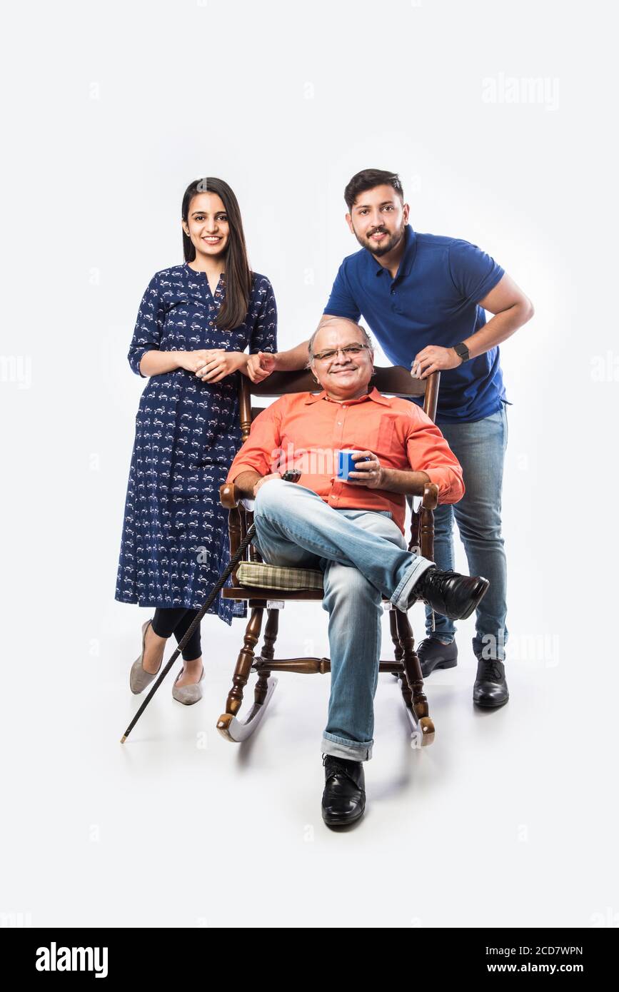 Vecchio o padre indiano con figlio e figlia, seduto su sedia a dondolo Foto Stock