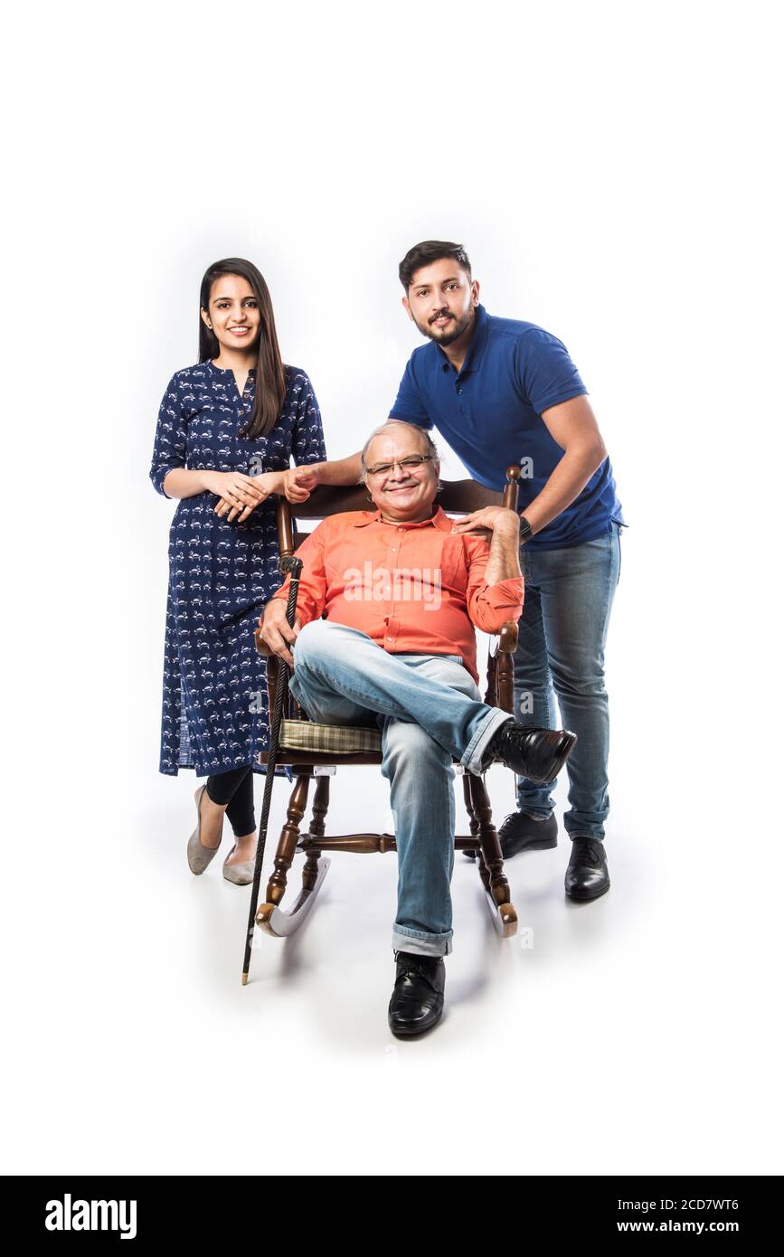 Vecchio o padre indiano con figlio e figlia, seduto su sedia a dondolo Foto Stock
