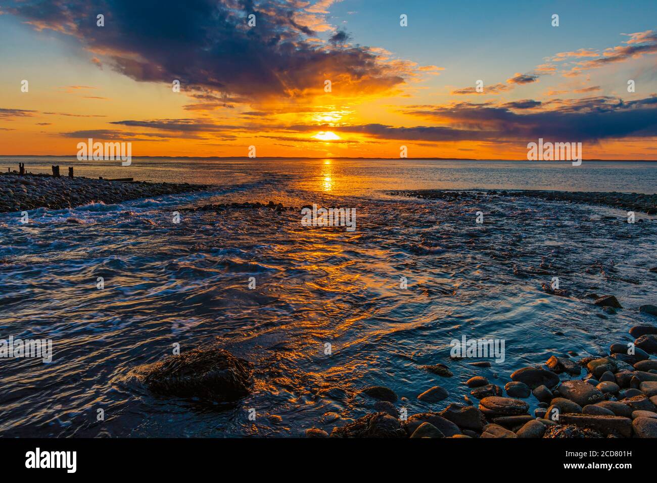 Bagliore arancione di tramonto del fiume che scorre nel mare. Foto Stock