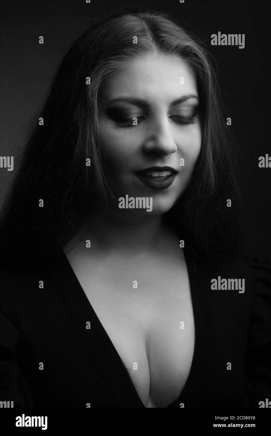 ritratto bianco e nero di una donna sovrappeso in un Studio su sfondo nero Foto Stock