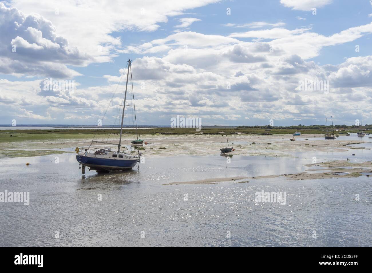 Barca singola sulla spiaggia a bassa marea. Concentrarsi sulla barca. Leigh sul Mare, Essex Foto Stock