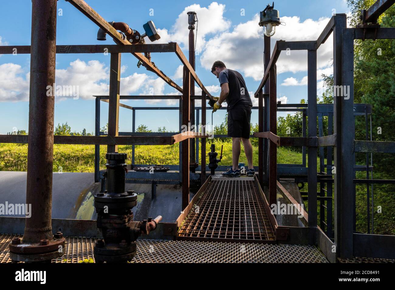 Operatore del petrolio greggio che controlla la quantità di olio nel serbatoio. Lavoratore onshore del petrolio greggio, controllo del livello del petrolio, serbatoio del greggio, lavoratore petrolifero, lavoratore del greggio, Foto Stock