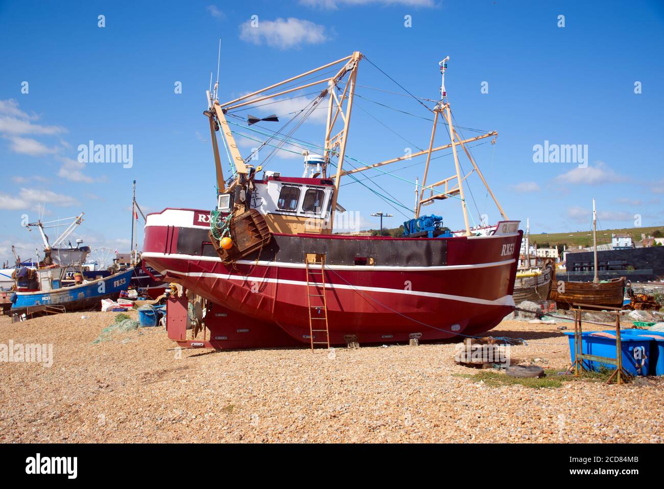 Barche da pesca sulla spiaggia di ciottoli del porto di Hastings, la più grande flotta peschereccia lanciata a terra in Europa. Foto Stock