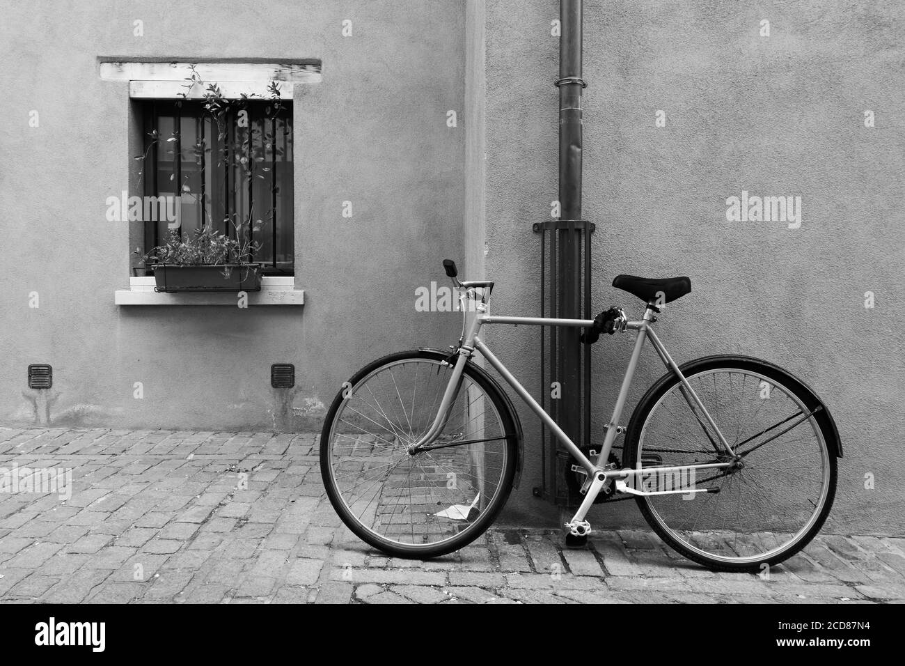 Biciclette parcheggiate in strada a Rimini, Italia. Fotografia urbana in bianco e nero Foto Stock
