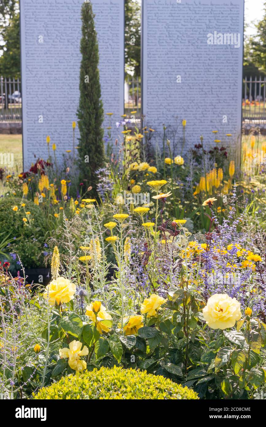 SIMBOLICHE PIANTAGIONI GIALLE E BLU DI FRONTE ALLA MAGNA CARTA SU DUE PILASTRI DI PIETRA DELLA MAGNA INTERNAZIONALE DI AMNESTY CARTA 800 GARDEN ALL'HAMPTON COU Foto Stock