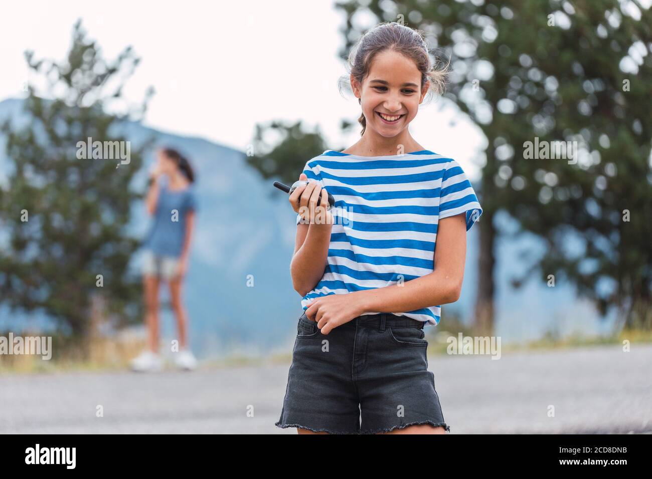 Due ragazze che comunicano tramite walkie-talkie durante un'escursione attraverso il boschi Foto Stock