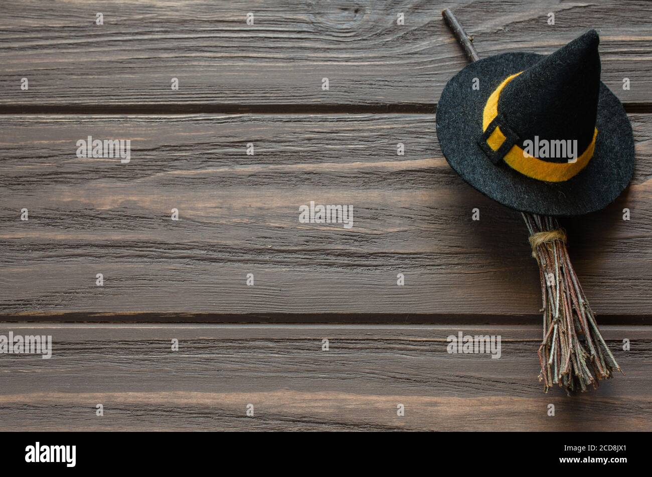 Happy Halloween sfondo vacanza con accessori strega: cappello e scopa su tavolo di legno. Foto Stock