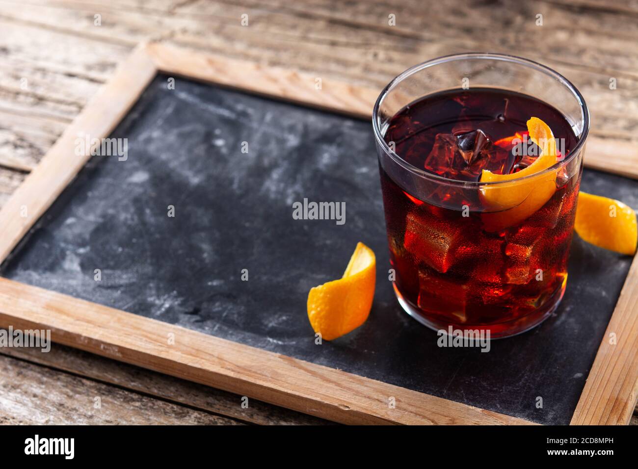 Cocktail Boulevardier e scorza d'arancia su sfondo di legno Foto Stock