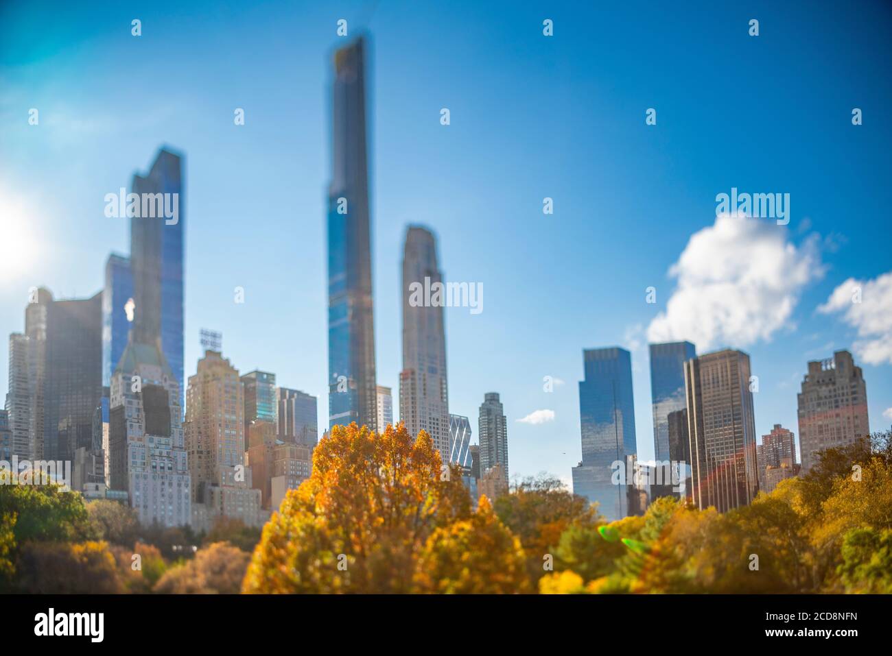 Il grattacielo di Manhattan si erge oltre gli alberi di colori autunnali in Central Park Foto Stock