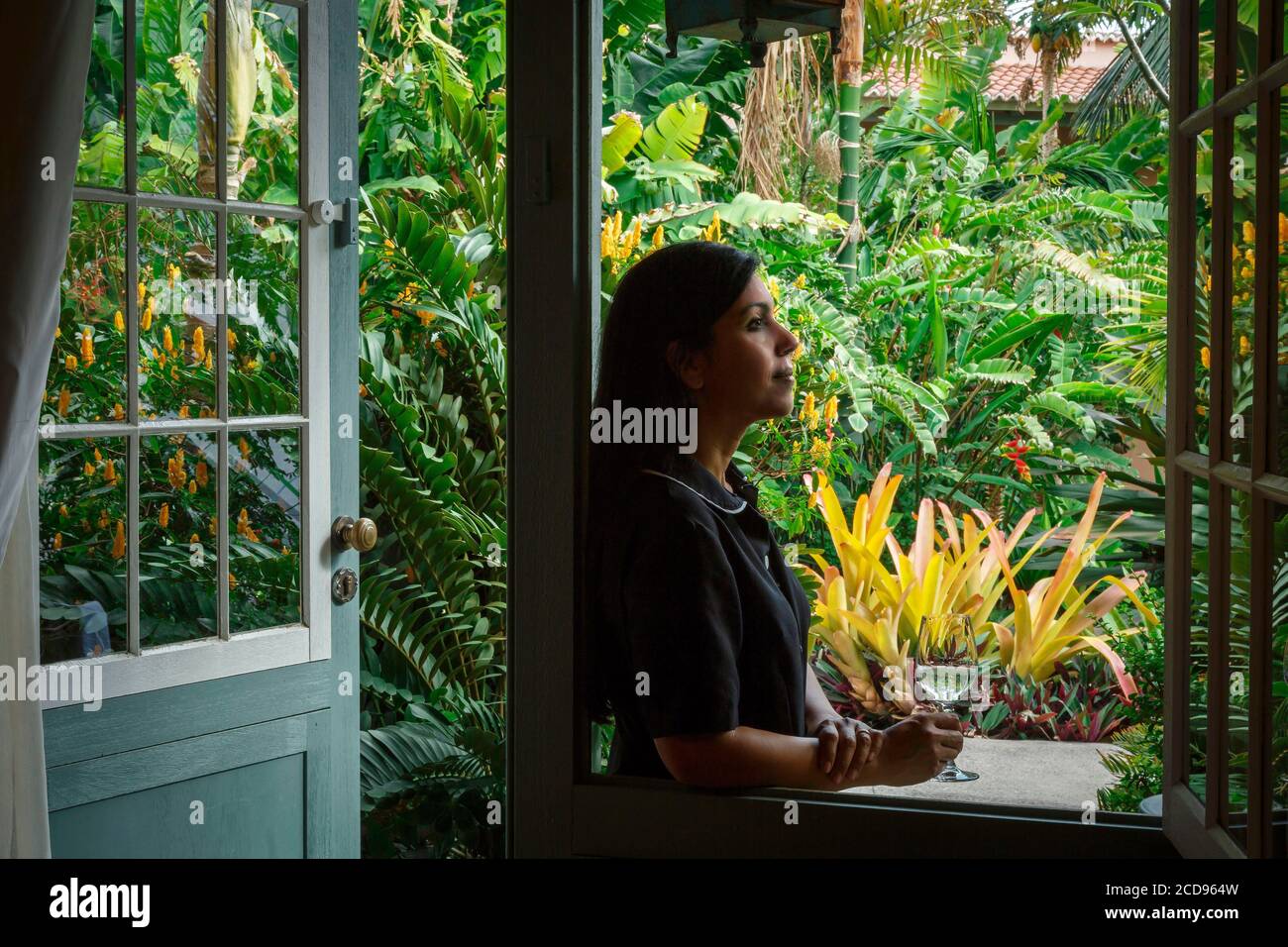 Spagna, Isole Canarie, la Palma, giovane donna sola sotto la veranda di un hotel di lusso in stile coloniale Foto Stock