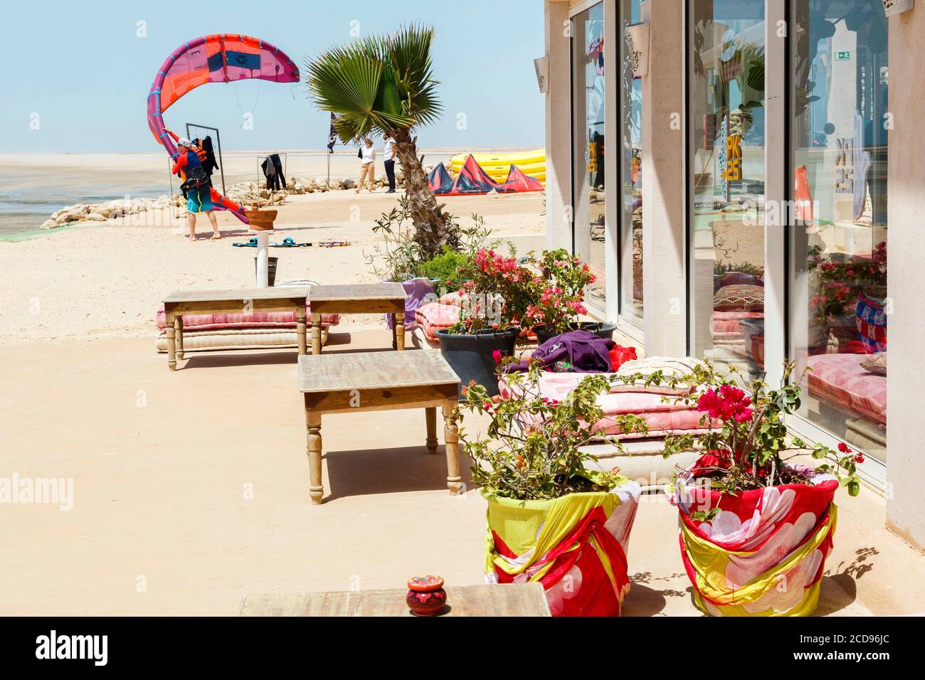 Marocco, Oued ed-Dahab, Dakhla, PK25 Resort, kite-surfer preparandosi a lasciare sull'acqua di fronte alla terrazza di un eco-Lodge Foto Stock