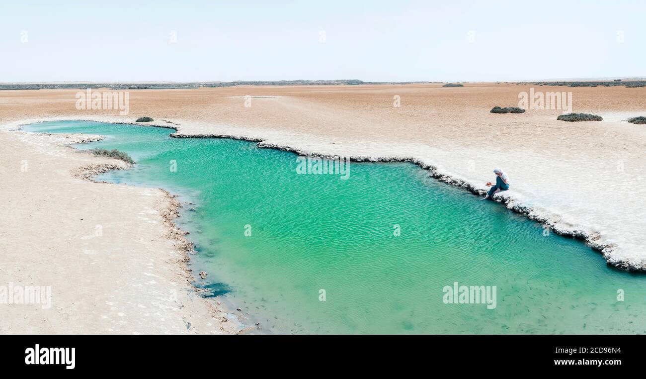 Marocco, Oued ed-Dahab, Dakhla, Imlili, personaggio ai margini di una buca d'acqua salata nel mezzo del deserto Foto Stock