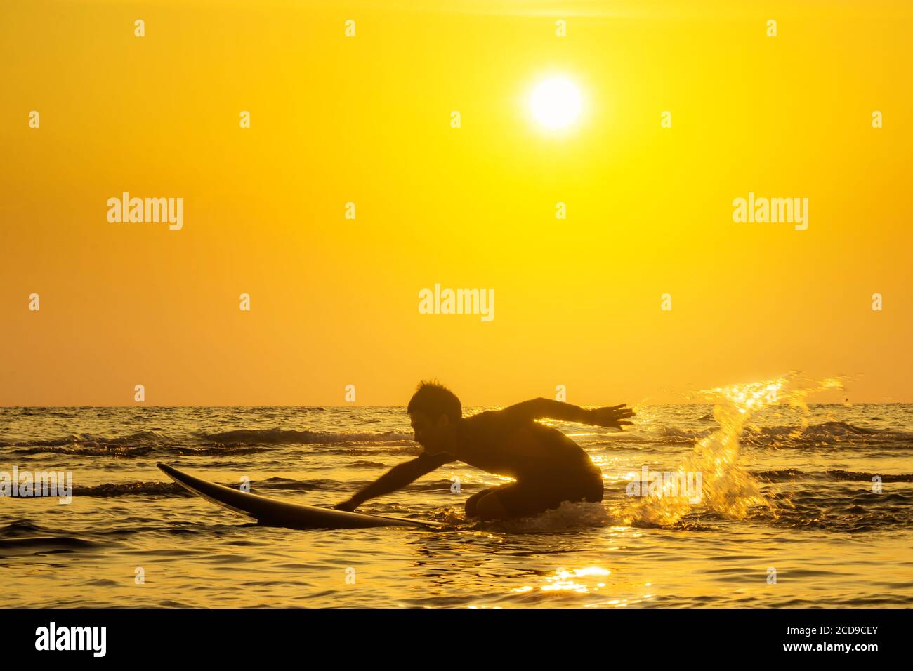 Surf al tramonto. Stile di vita attivo all'aperto. Sport acquatici estivi. Foto Stock