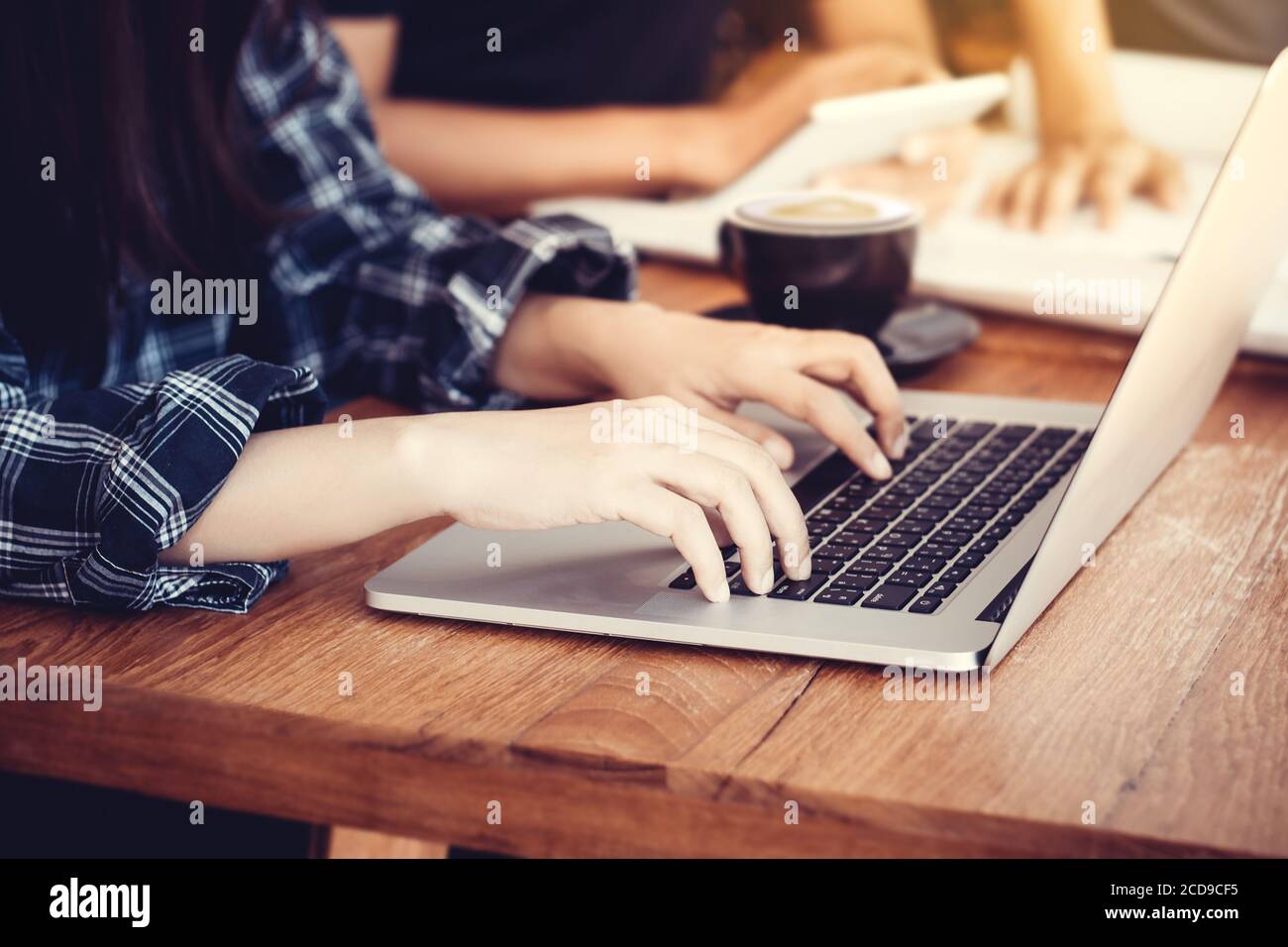 Uomo d'affari seduto alla scrivania dell'ufficio e digitando su un portatile le mani da vicino, faccia anonima Foto Stock