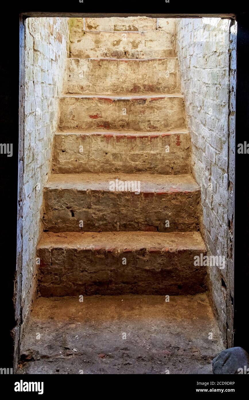 Vecchia scala di pietra collassante che conduce dal seminterrato. Foto Stock