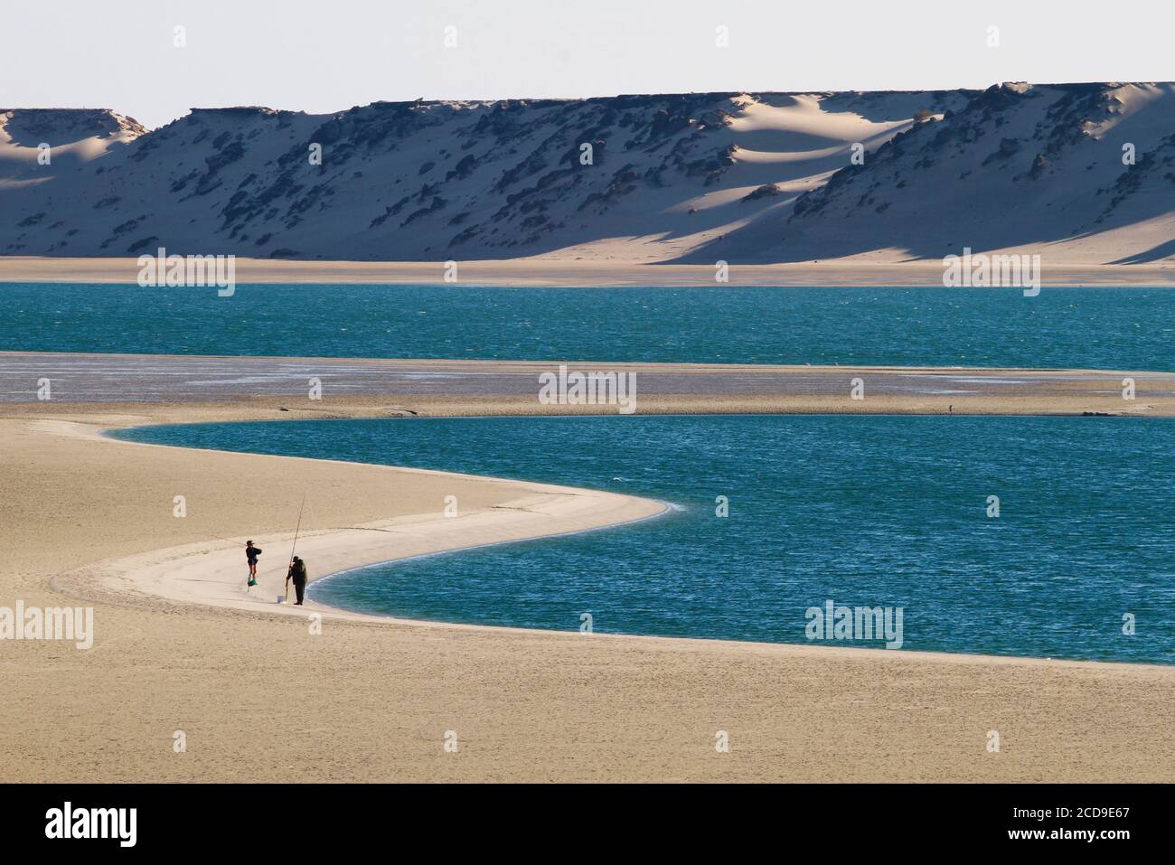 Marocco, Sahara occidentale, Dakhla, spiaggia che confina con la laguna con le montagne del deserto sullo sfondo Foto Stock