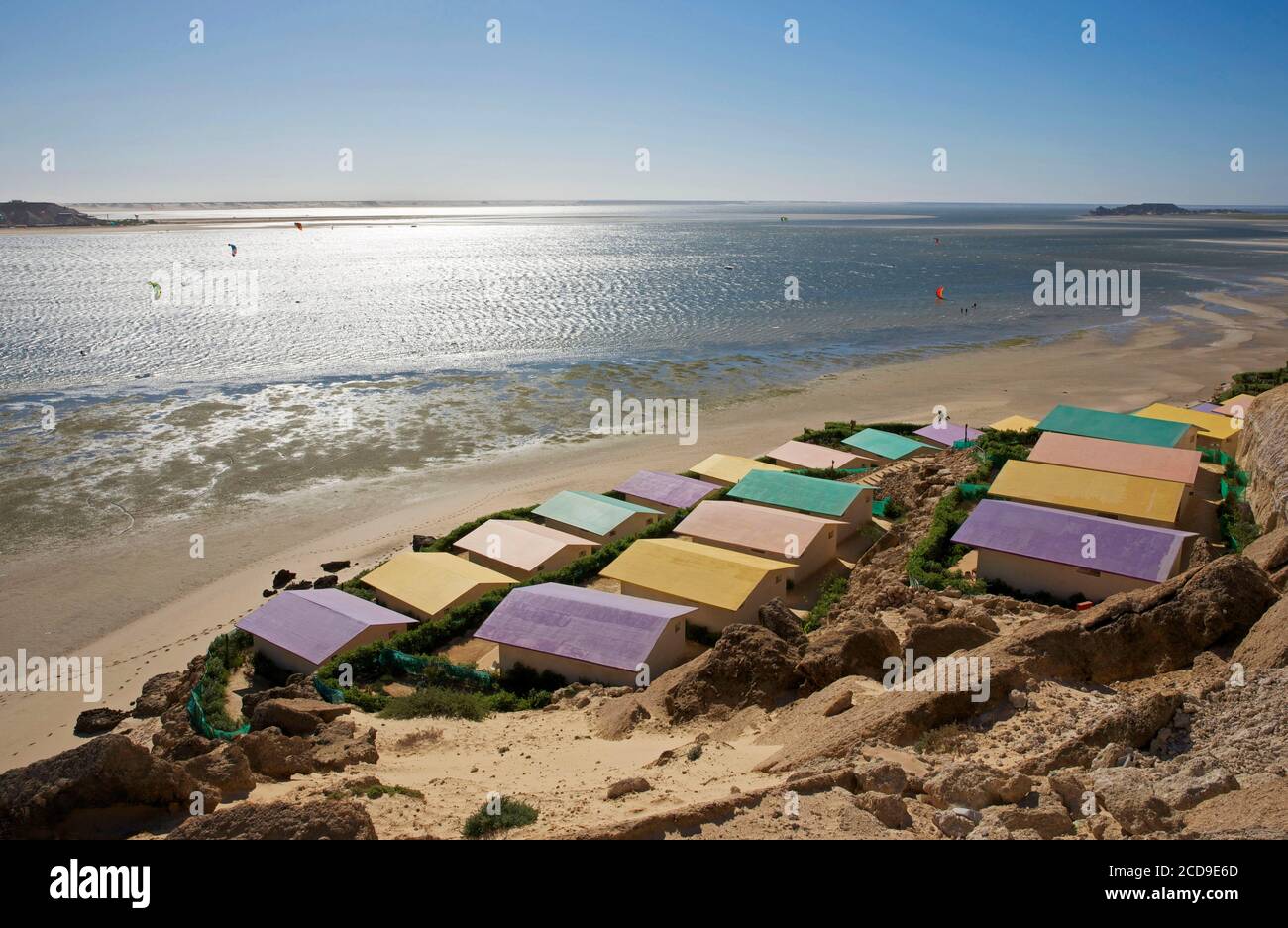 Marocco, Sahara occidentale, Dakhla, tetti colorati dell'hotel PK25 di fronte alla laguna e le montagne del deserto Foto Stock