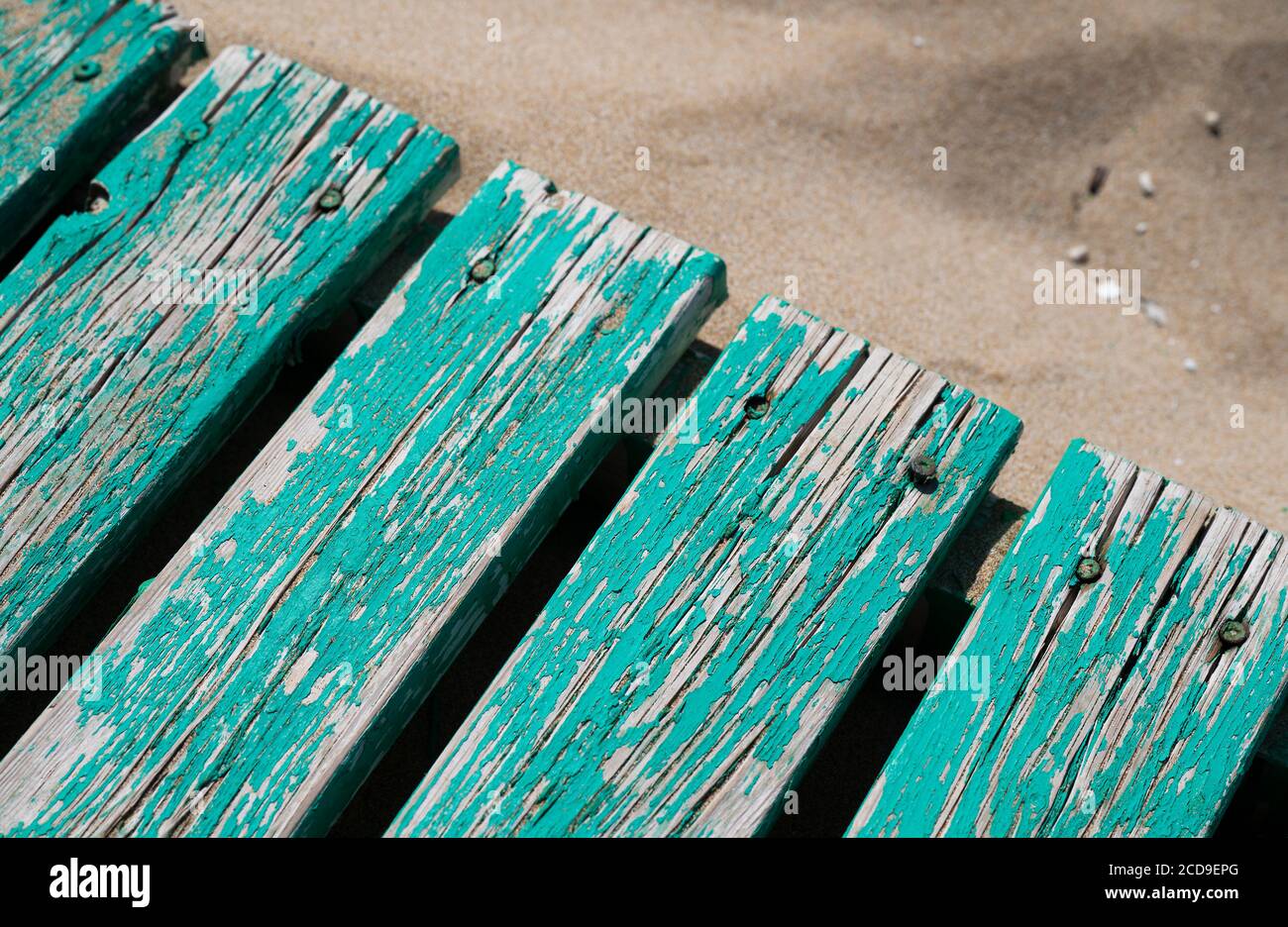 Una passerella sulla spiaggia di Stalida, Creta, Grecia. Battuto dal sole caldo, è molto resistente alle intemperie, la vernice sfaldando la secca parche Foto Stock