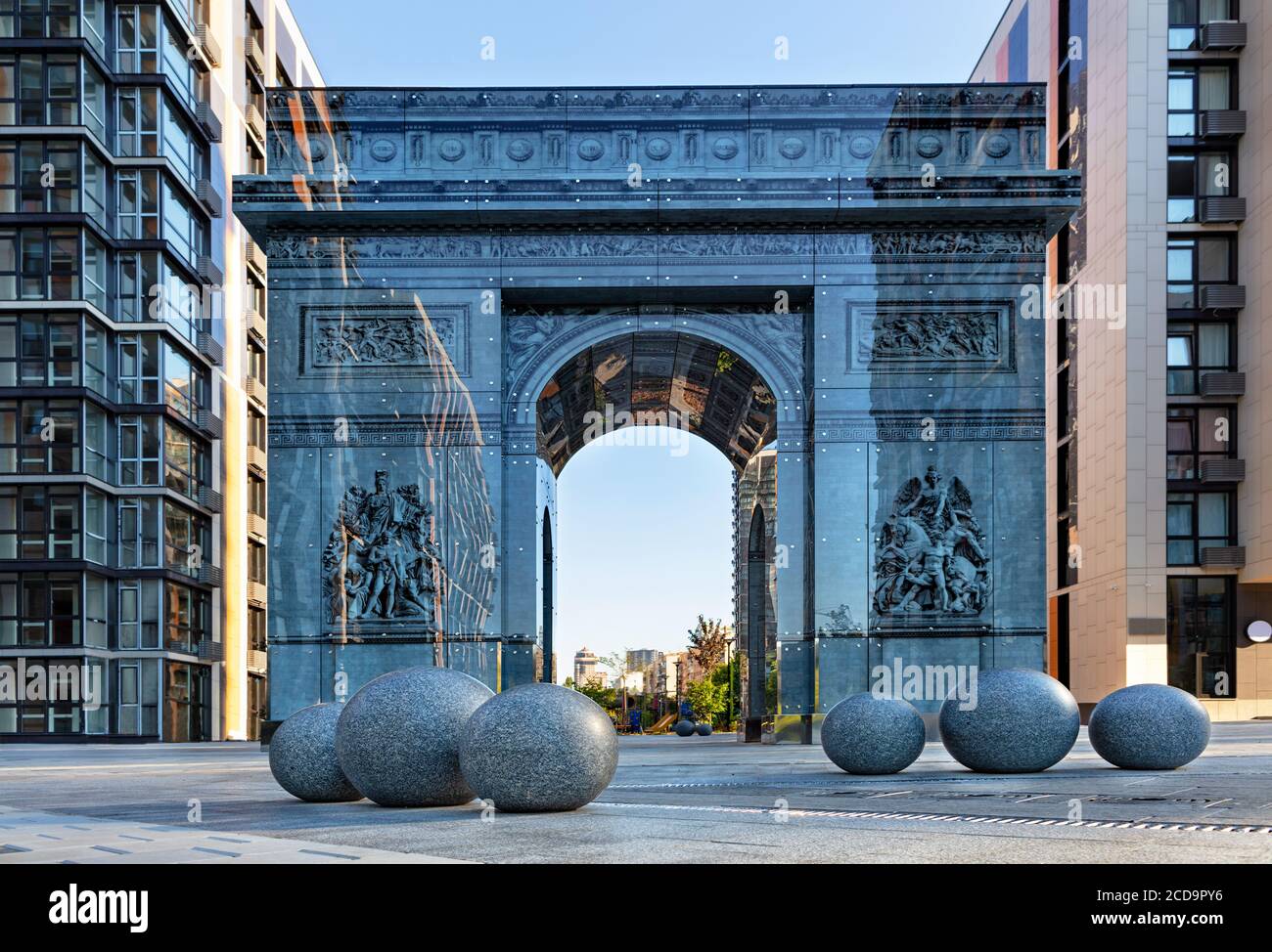 Kyiv, Ucraina, stilizzata come l'Arco di Trionfo sotto il famoso Arco di Trionfo a Parigi con grandi palle di granito in primo piano. Foto Stock