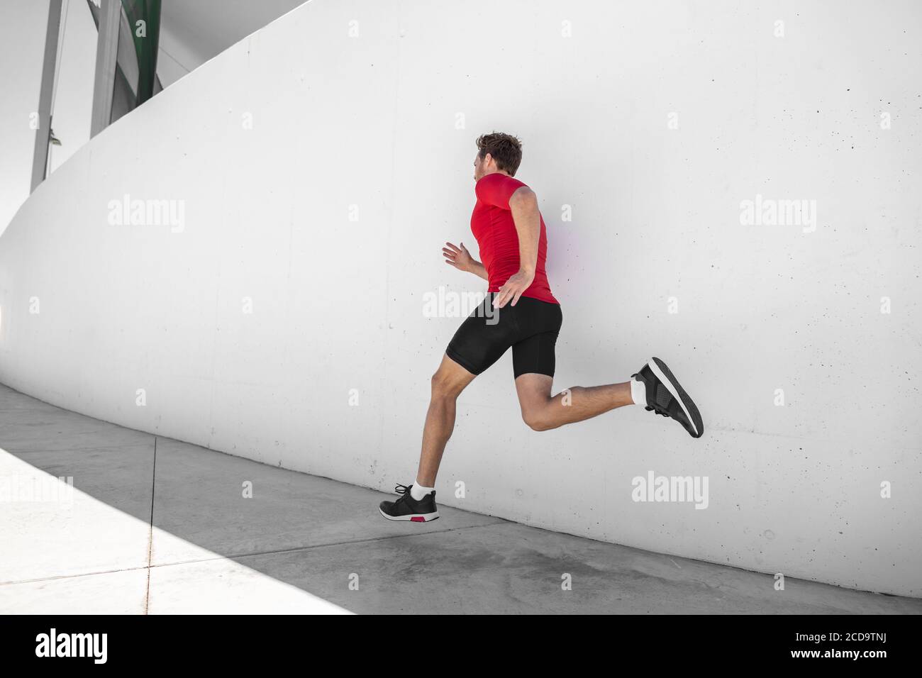 Atleta uomo che corre via sprinting facendo allenamento cardio hiit allenamento in palestra esterna estiva. Jogging maschile corridore Foto Stock