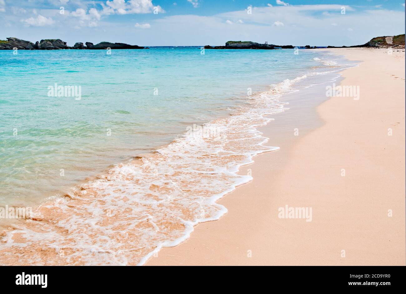 Spiaggia panoramica di sabbia rosa allacciata con le onde oceaniche a Copper's Island, Bermuda Foto Stock