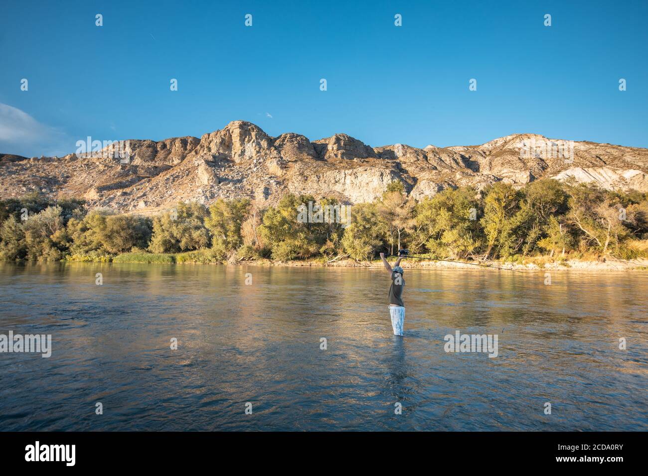 Pesca maschile nel lago con una canna da pesca Foto Stock