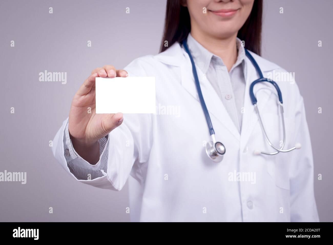 Concetto sano : giovane medico asiatico con biglietto da visita in mano, volto anonimo Foto Stock