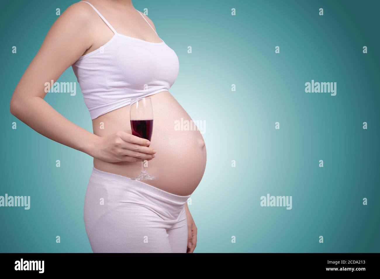 Concetto sano incinta. Un ritratto di una bella donna asiatica incinta con un bicchiere di vino in Hand.Clipping percorso includere Foto Stock