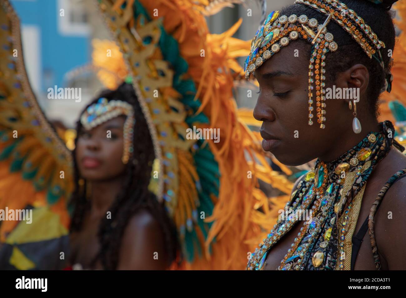 Donna partecipante in un bellissimo costume visto perso nei pensieri prima dell'inizio della sfilata del Carnevale di Notting Hill 2019. Foto Stock