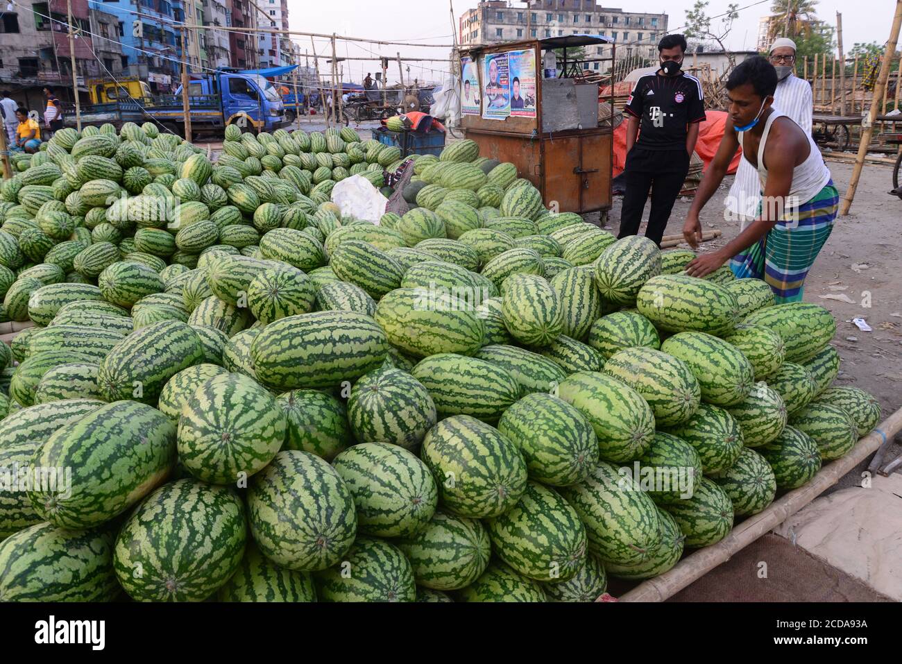 Il fornitore di angurie del Bangladesh attende il cliente in un mercato della cucina durante il governo ha imposto lo spegnimento come misura preventiva contro COVID-19 Foto Stock