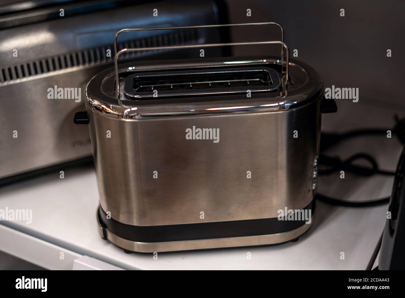 Tostapane da studio. Forno con tostapane in acciaio inox a due fette. Apparecchi elettrici, domestici, da cucina in metallo grigio. Messa a fuoco selettiva Foto Stock
