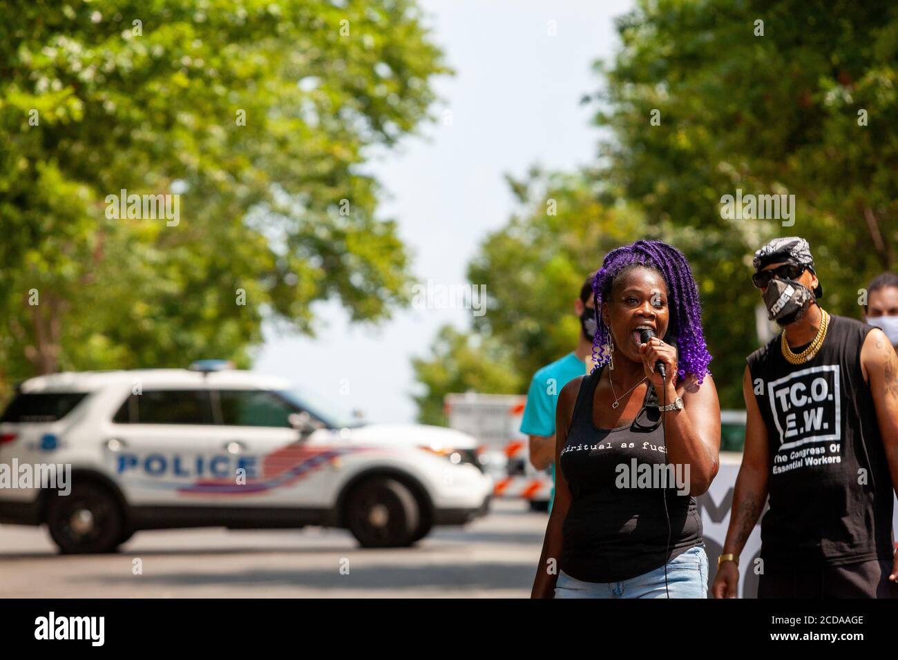 Washington, DC, Stati Uniti. 27 Agosto 2020. Nella foto: Tanesha Grant of Mothers United for Black Lives si rivolge al gruppo riunito per il Rally per i diritti dei lavoratori, come una polizia metropolitana (DC) pattuglia auto blocca la strada in background. Il raduno si è verificato al di fuori della casa di Jeff Bezos per sostenere i diritti dei lavoratori essenziali a una retribuzione adeguata e condizioni di lavoro sicure. Credit: Allison C Bailey/Alamy Credit: Alison Bailey/Alamy Live News Foto Stock