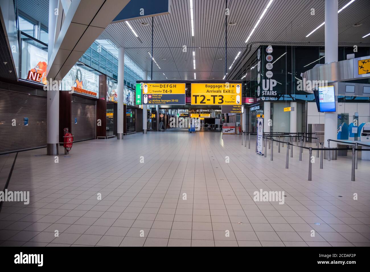 Aeroporto di Schiphol, Paesi Bassi - 27 giugno 2020: Sala deserta con negozi chiusi a causa di restrizioni di viaggio a causa della pandemia di covid-19 Foto Stock