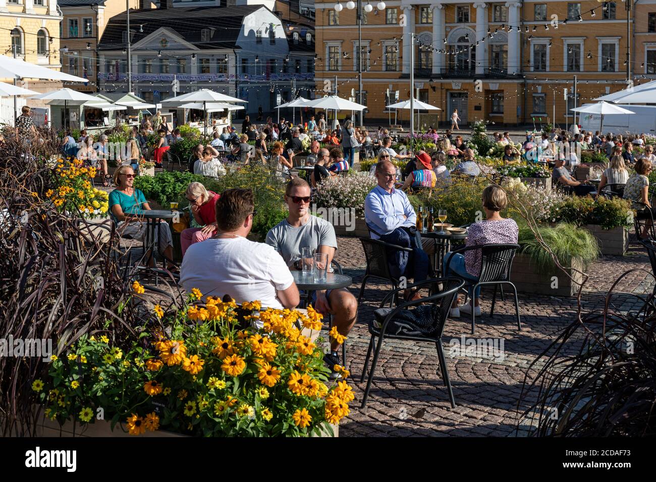 Le persone gustano bevande sulla gigantesca terrazza estiva di Piazza del Senato a Helsinki, Finlandia Foto Stock