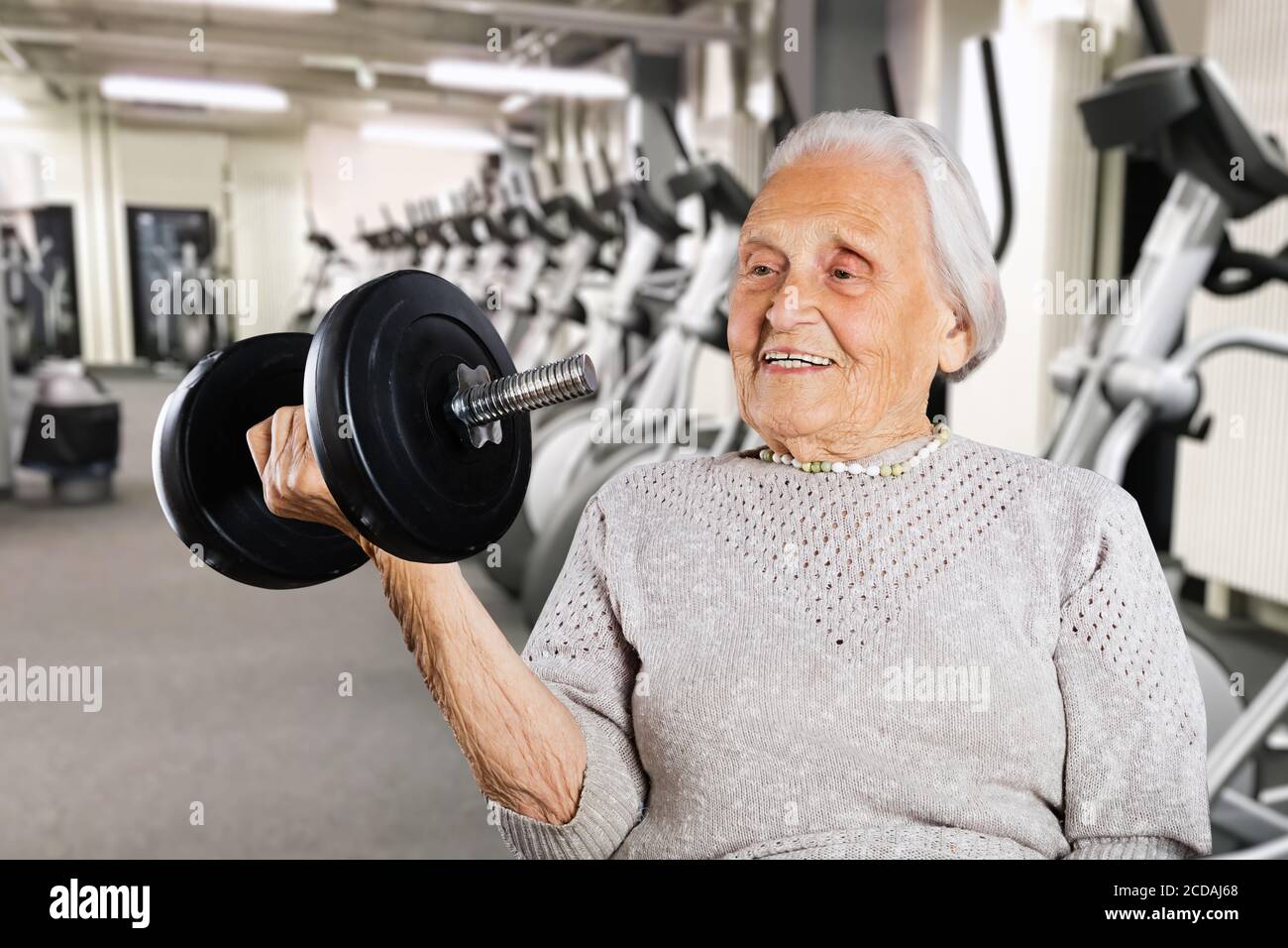 Forte nonna ritirata Donne che sollevano il peso mentre si esercita Foto Stock