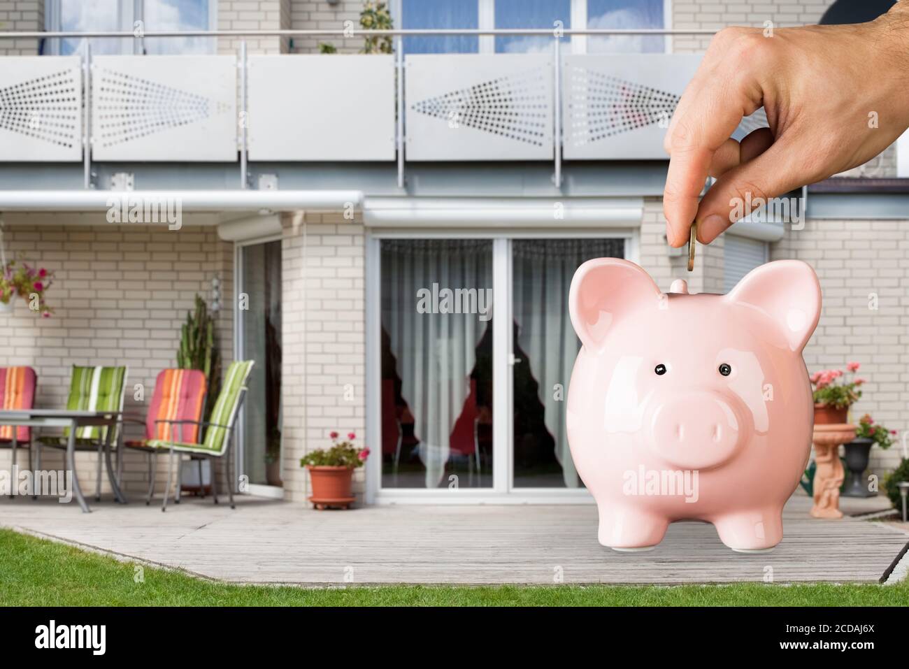 Piano finanziario investimenti immobiliari. Moneta di salvataggio in Piggybank Foto Stock