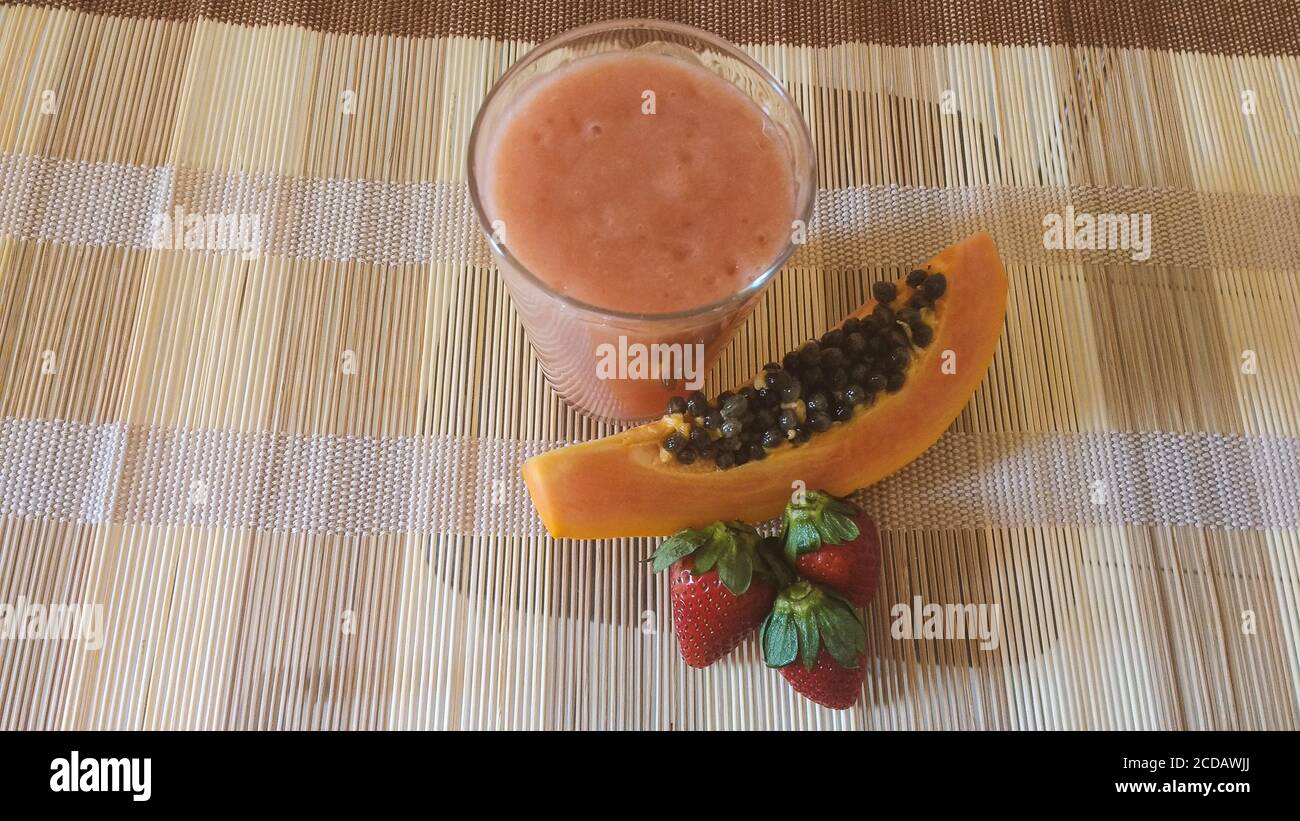 Vitamina vegana sul tavolo - fragola, papaya e banana mix. Foto Stock