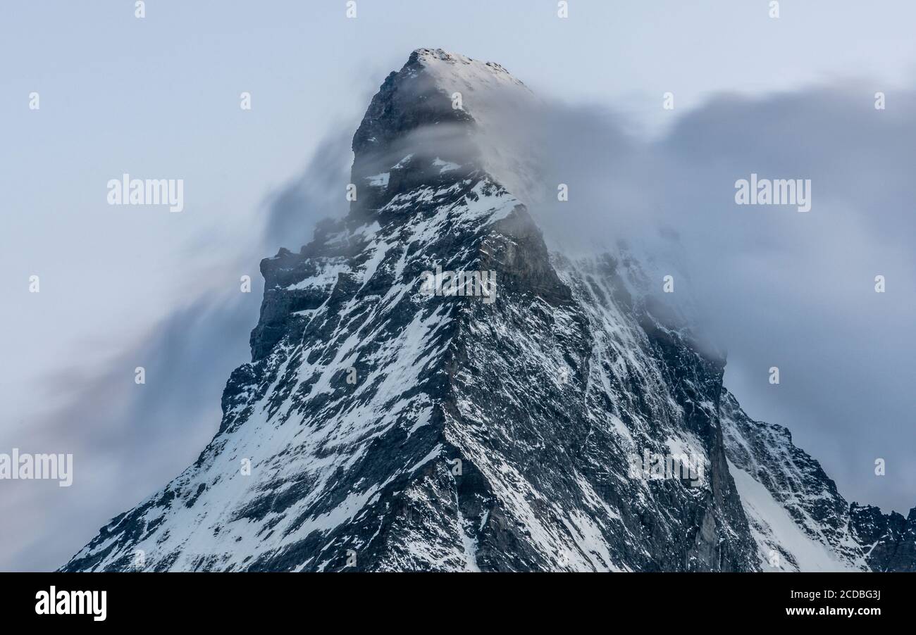 Lungo scatto di esposizione della vetta innevata del Cervino con nuvole passando davanti al monte al tramonto durante l'estate Tratto da Zermatt nelle Alpi svizzere Foto Stock